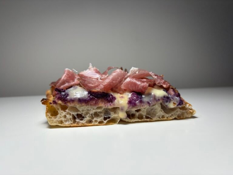 Pizza cu prosciutto și sos de afine.